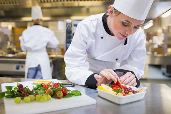 Chefe feminino preparando uma salada em uma cozinha de restaurante
